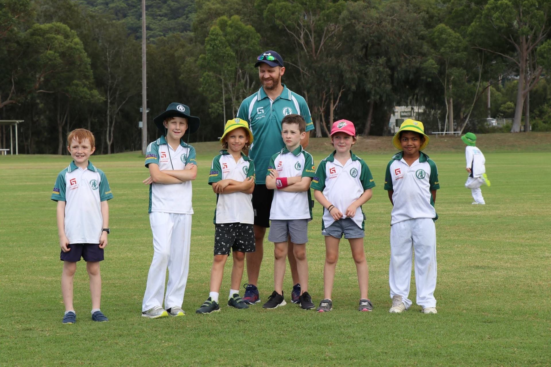 Junior Lions lined up with their coach on the field